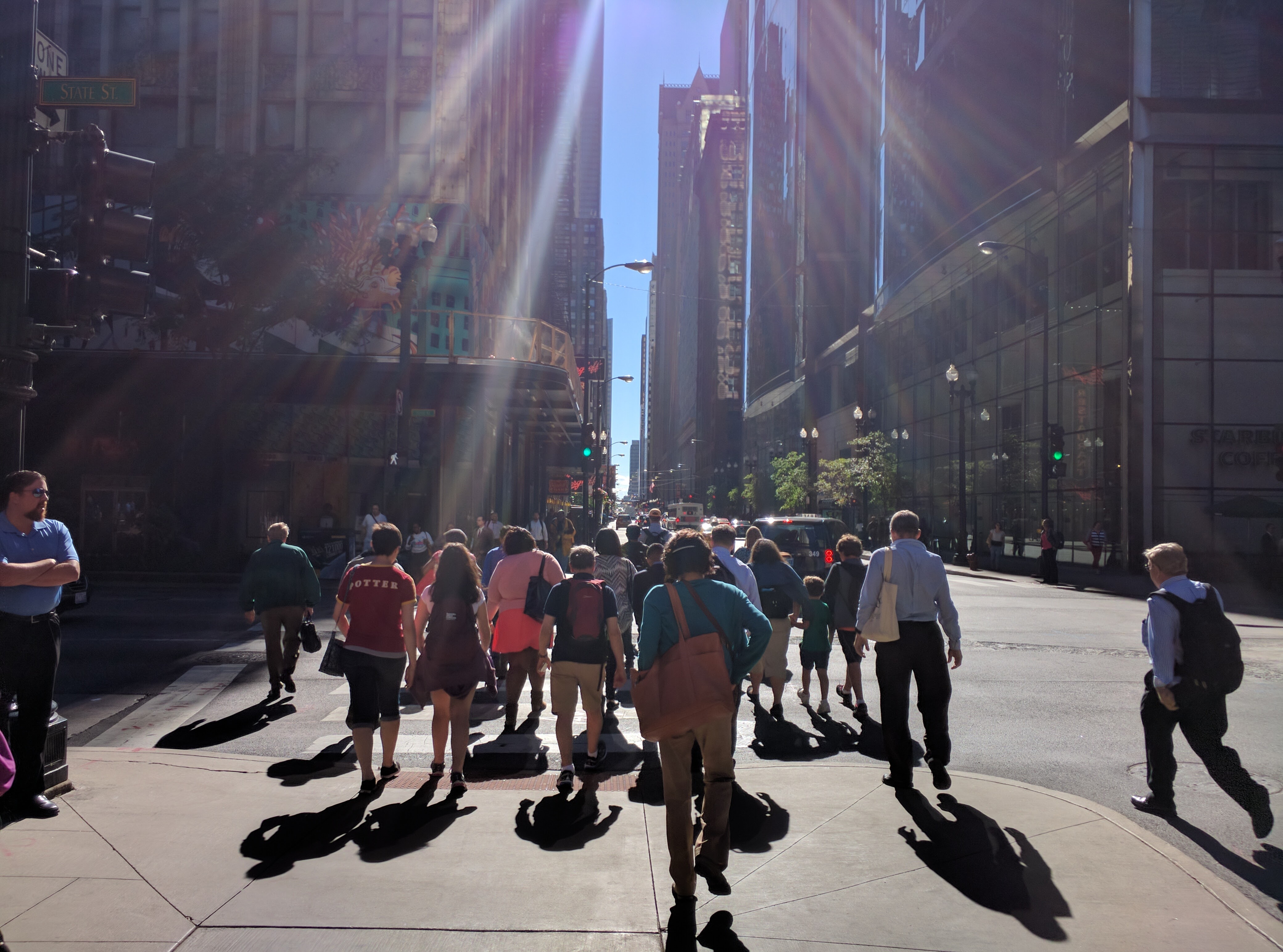 People walking through a sunlit city street